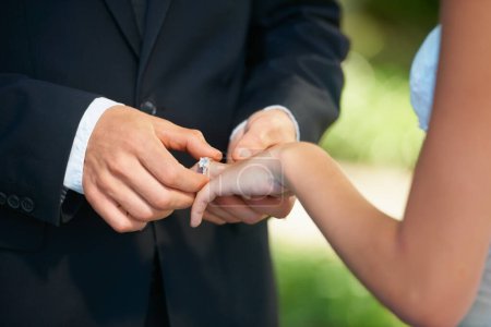 Photo for With this ring, I thee wed...Cropped image of a groom putting the ring on his brides finger on their wedding day - Royalty Free Image