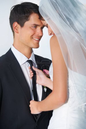 Téléchargez les photos : A partir de ce jour... une jeune mariée tirant affectueusement sur la cravate de son mari - en image libre de droit