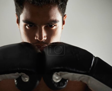 Téléchargez les photos : Prêt pour les nouveaux arrivants. Portrait d'un jeune boxeur masculin en position de combat - en image libre de droit