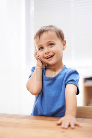 Photo for Giving Grandma a call. a young boy talking on a cellphone - Royalty Free Image