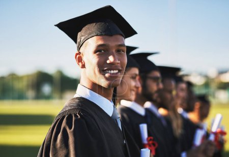 Photo for Dreams dont work unless you do. Portrait of a smiling university student on graduation day with classmates in the background - Royalty Free Image