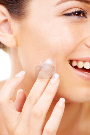 Photo for Taking care of her skin. Cropped image of a young woman applying lotion to her face - Royalty Free Image