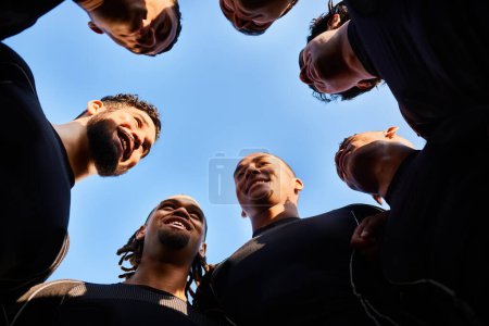 Photo for We win through teamwork. Low angle shot of a diverse group of sportsmen huddled together before playing a game of rugby - Royalty Free Image
