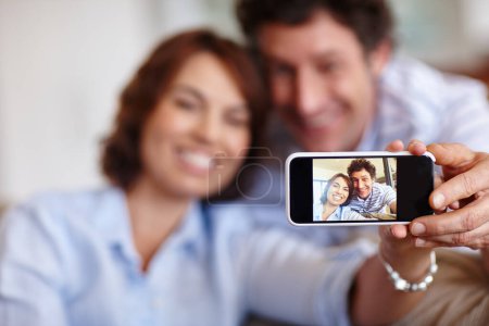 Téléchargez les photos : La façon la plus intelligente de sauver des souvenirs. un mari et sa femme prenant un selfie ensemble à la maison - en image libre de droit