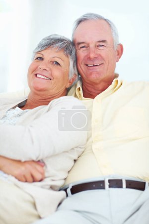 Foto de Pareja madura sonriente en casa. Retrato sonriente pareja madura en casa relajarse en el sofá - Imagen libre de derechos