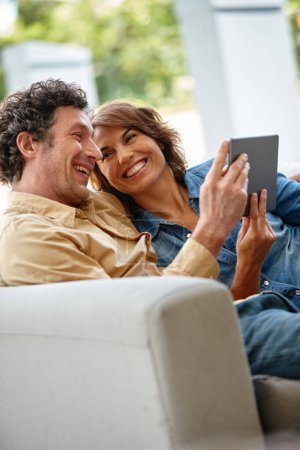 Téléchargez les photos : Partager, c'est prendre soin de soi. un mari et une femme utilisant une tablette numérique ensemble à la maison - en image libre de droit