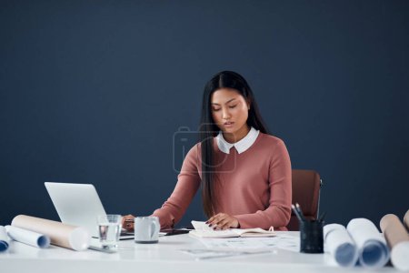 Photo for Planning my busy schedule for the rest of the week. an attractive young female architect working on a laptop in her office - Royalty Free Image