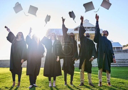Photo for World, were so ready for you. a group of students throwing their hats in the air on graduation day - Royalty Free Image