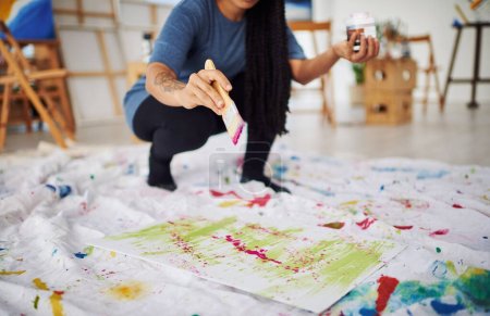 Téléchargez les photos : Jouez avec la peinture et créez votre chef-d'œuvre. une femme méconnaissable peignant dans un atelier d'art - en image libre de droit