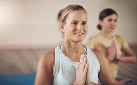 Téléchargez les photos : Méditation et yoga vont de pair. deux jeunes femmes assises ensemble et méditant avec leurs paumes ensemble après une séance de yoga intérieur - en image libre de droit