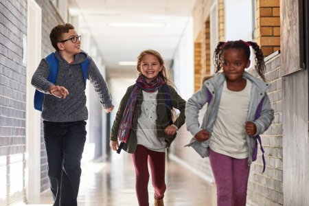 Foto de Corriendo a clase. niños de primaria corriendo en el pasillo de la escuela - Imagen libre de derechos
