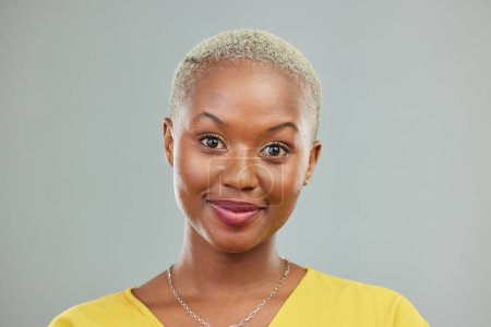 Photo for Happy, portrait and woman in studio with confidence, cool and edgy against a grey or wall background. Headshot, face and young african female model smile, cheerful and proud, satisfied and beautiful. - Royalty Free Image