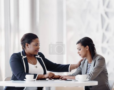 Photo for Well get through this together. an attractive young businesswoman being consoled by a female colleague in their workplace - Royalty Free Image