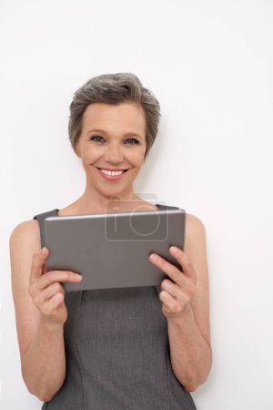 Photo for Shes never out of reach. Portrait of a mature businesswoman holding a digital tablet - Royalty Free Image