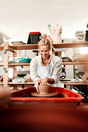 Téléchargez les photos : Concentrez-vous sur ce que vous aimez et gagnez de l'argent. une femme artisan travaillant dans son atelier de poterie - en image libre de droit