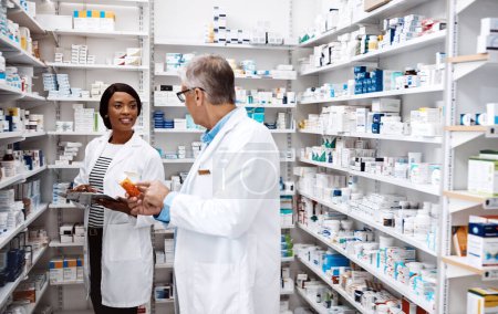 Foto de ¿Qué producto crees que vende más? dos farmacéuticos trabajando juntos en una farmacia - Imagen libre de derechos