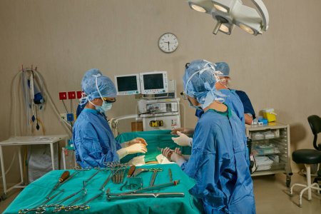 Téléchargez les photos : Spécialisée dans les chirurgies réussies. une équipe de chirurgiens effectuant une opération dans une salle d'opération - en image libre de droit