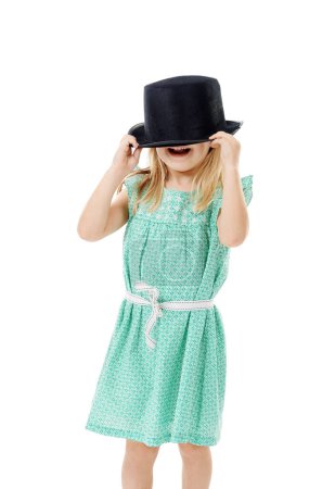 Foto de Apuesto a que no puedes verme. Foto de estudio de una linda niña con un sombrero funky sobre un fondo blanco - Imagen libre de derechos