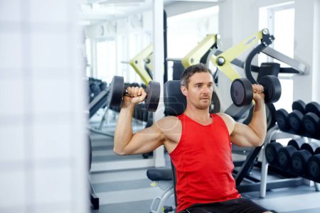Photo for Pushing his limits. A handsome young man doing weight training at the gym - Royalty Free Image