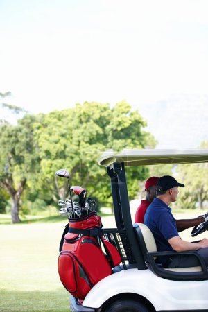 Photo for On the hunt for a missing ball. two men in a cart driving across a golf course - Royalty Free Image