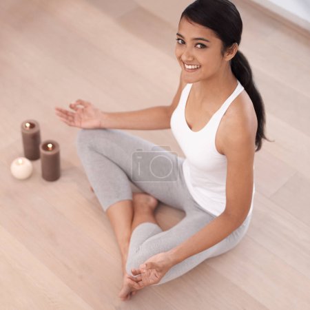 Photo for Meditation puts a smile on her face. High angle portrait of a beautiful young woman meditating at home - Royalty Free Image