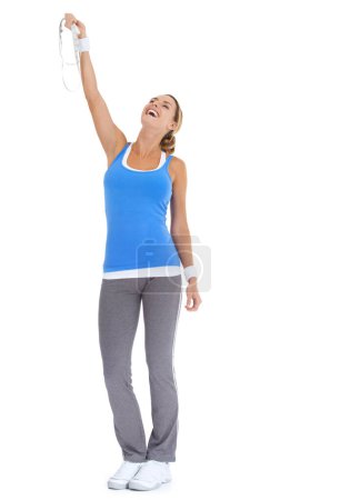Foto de Alcanzó sus objetivos de fitness. Mujer joven y saludable expresando triunfo mientras sostiene una cinta métrica y aislado en blanco - Imagen libre de derechos