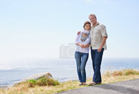 Photo for Taking in the breathtaking view. A couple holding each other walking along the road - Royalty Free Image