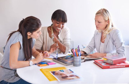 Téléchargez les photos : Utilisant leur créativité collective. trois femmes d'affaires réunies autour d'une table dans le bureau - en image libre de droit