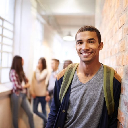 Photo for Campus life has been good to me. Portrait of a handsome young male student leaning against a wall with his friends in the background - Royalty Free Image