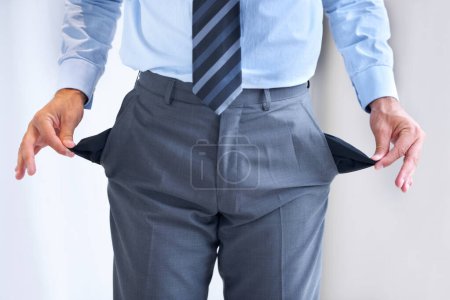 Foto de Recogiendo sus bolsillos. un hombre de negocios de pie con sus bolsillos resultó - Imagen libre de derechos