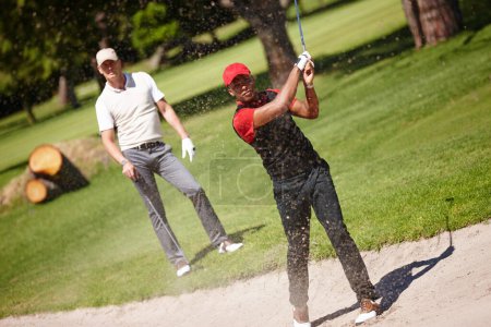 Téléchargez les photos : Sûr de son tir. deux beaux hommes jouant à un jeu de golf - en image libre de droit