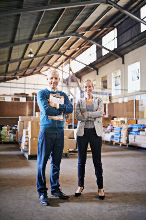 Photo for Let us coordinate you transport. Portrait of two managers standing in a distribution warehouse - Royalty Free Image