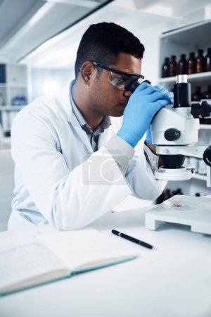 Photo for The cure is closer than you think. a young scientist using a microscope in a laboratory - Royalty Free Image