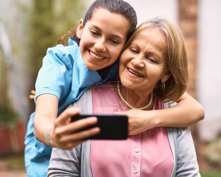 Téléchargez les photos : Étaient aussi proches que la famille. un aidant prenant un selfie avec un patient âgé à l'extérieur - en image libre de droit