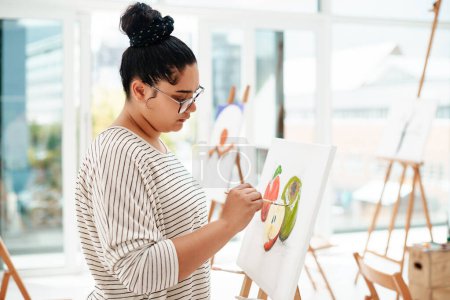 Photo for Less is always more. an attractive young artist standing alone and painting during an art class in the studio - Royalty Free Image