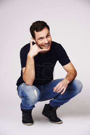 Photo for Man, portrait and call me hand sign of a person with flirty and emoji gesture in studio. Isolated, grey background and male model with a smile and happiness from flirt and casual fashion alone. - Royalty Free Image