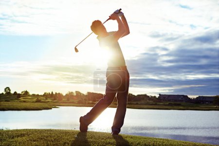 Téléchargez les photos : Le maître de tous les tirs. un homme pratiquant son swing sur le terrain de golf - en image libre de droit