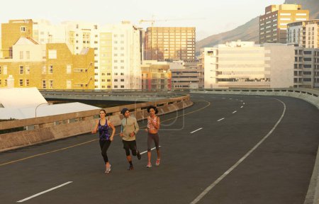 Foto de Las calles son todas nuestras. corredores corriendo por una carretera vacía en la mañana - Imagen libre de derechos