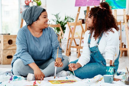 Photo for Painting brings us closer together. Full length shot of two attractive young artists sitting together and painting during an art class in the studio - Royalty Free Image