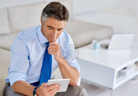 Photo for Checking the online financials. a mature businessman using a tablet while sitting on a sofa - Royalty Free Image