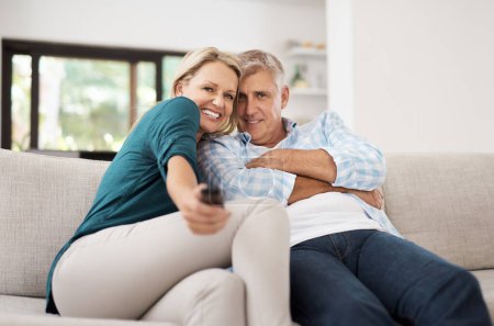 Photo for Cozying up on the couch. Cropped portrait of an affectionate mature couple watching television together at home - Royalty Free Image