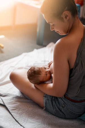 Foto de Todo el alimento que necesita. Foto de ángulo alto de una madre joven amamantando a su bebé recién nacido en casa - Imagen libre de derechos