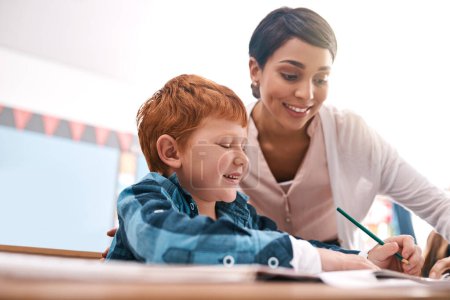 Photo for You almost got it. a cheerful young female teacher helping a student inside of the class at school - Royalty Free Image