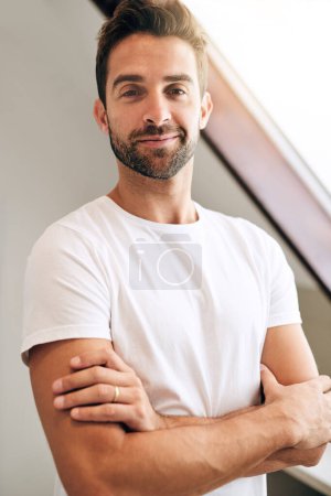 Photo for Feeling confident about the day ahead. a handsome young man standing with his arms crossed in his bedroom at home - Royalty Free Image