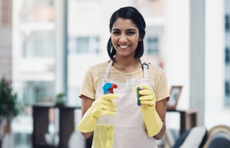 Photo for Just call me the queen of clean. a young woman using rubber gloves and disinfectant to clean her home - Royalty Free Image