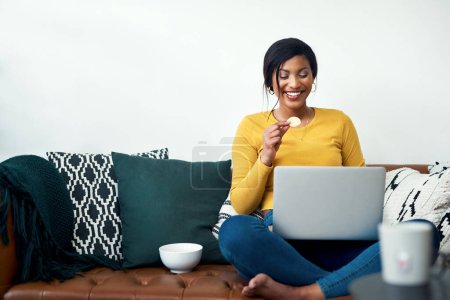 Photo for Sofa, laptop and woman eating chips for movie, video streaming service or subscription at home. Happy african person watch film with potato chip, computer and internet connection on living room couch. - Royalty Free Image