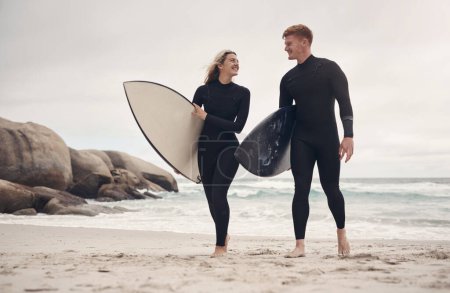Photo for You had me at Do you surf. a young couple out at the beach with their surfboards - Royalty Free Image