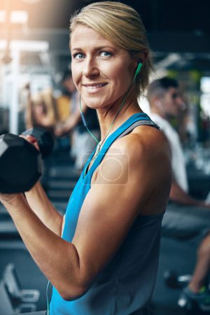 Foto de El progreso lento es mucho mejor que las excusas rápidas. una mujer haciendo ejercicios de peso en el gimnasio - Imagen libre de derechos