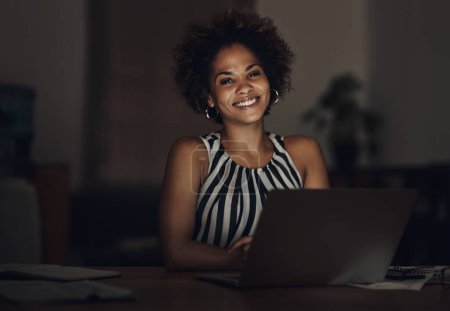 Photo for Whats one night of lost sleep when youre building success. Portrait of a young businesswoman using a laptop during a late night at work - Royalty Free Image