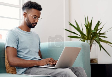 Photo for There are emails to attend to. a handsome young businessman sitting alone and using his laptop in the office - Royalty Free Image